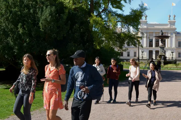 Students walking together in front of the Main University Building during a campus tour. Photo.