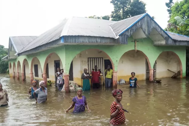 People wading through water flooding 