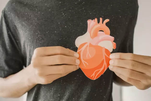 Man holding paper cutout of a heart