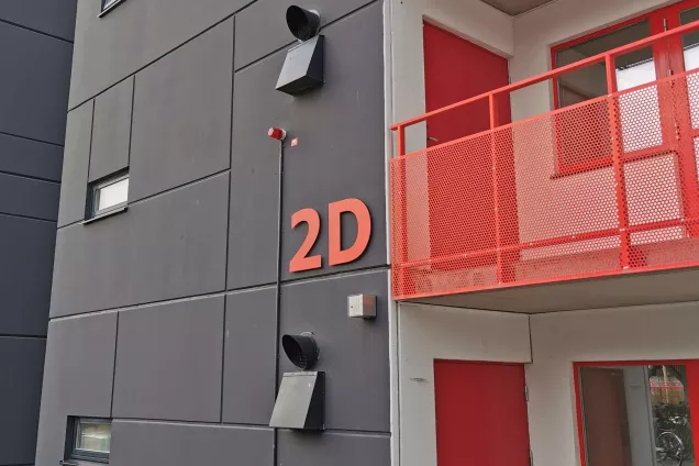 A red balcony on a grey building