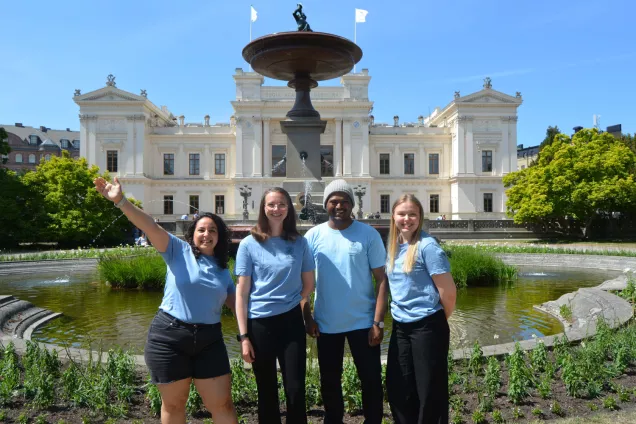 Four international mentors posing together in front of the Main University Building. Photo.