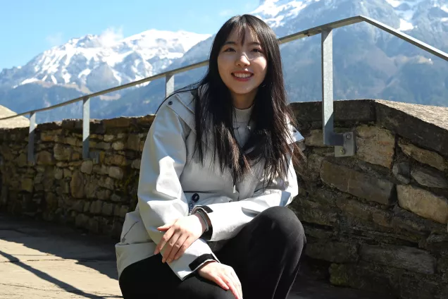 The student Qinxin in front of a mountain. Photo.