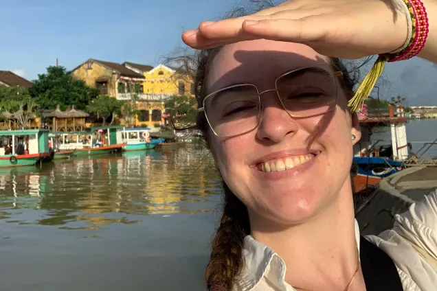 A student posing on a boat in Asia. Photo.