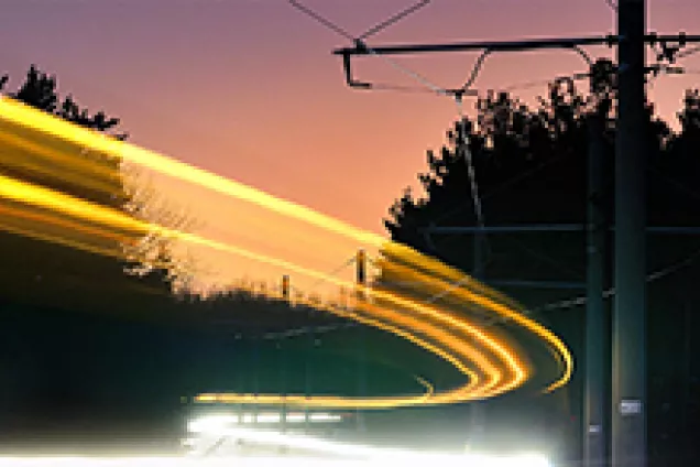 a trail of light above train tracks