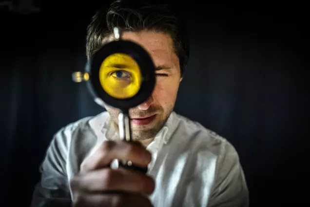 Man with magnifying glass. Photo: Kennet Ruona.