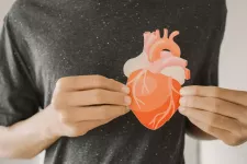 Man holding paper cutout of a heart