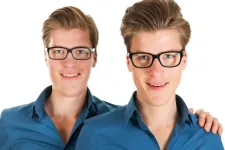 Two identical twins wearing glasses