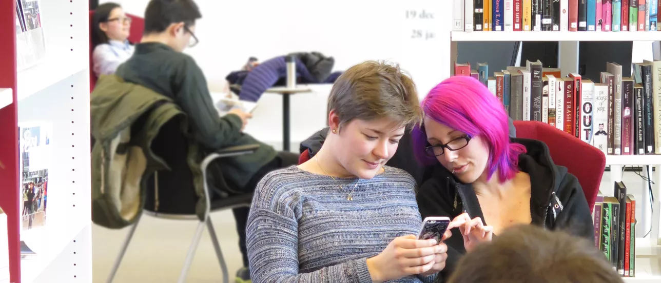 Students looking at a phone together in the Asian Studies library