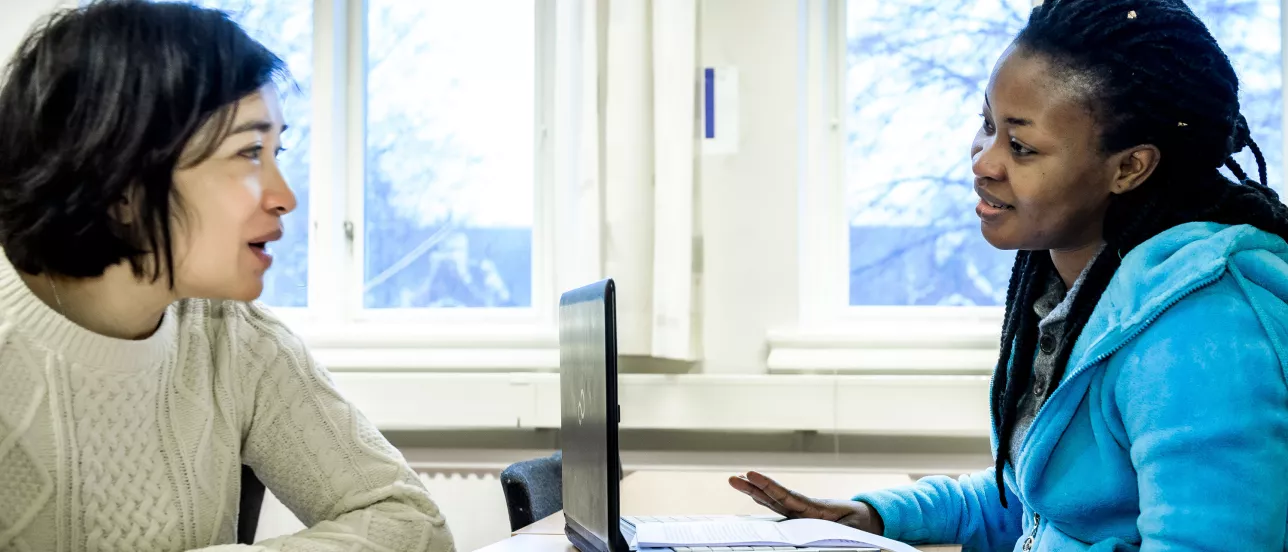 Two students discussing something in a classroom