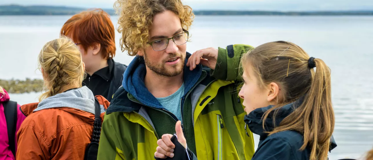 Students talking on an excursion at a lakeside