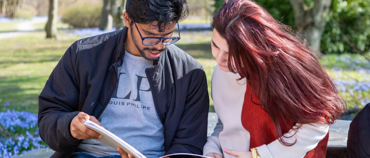 Two students reading a book. Photo.