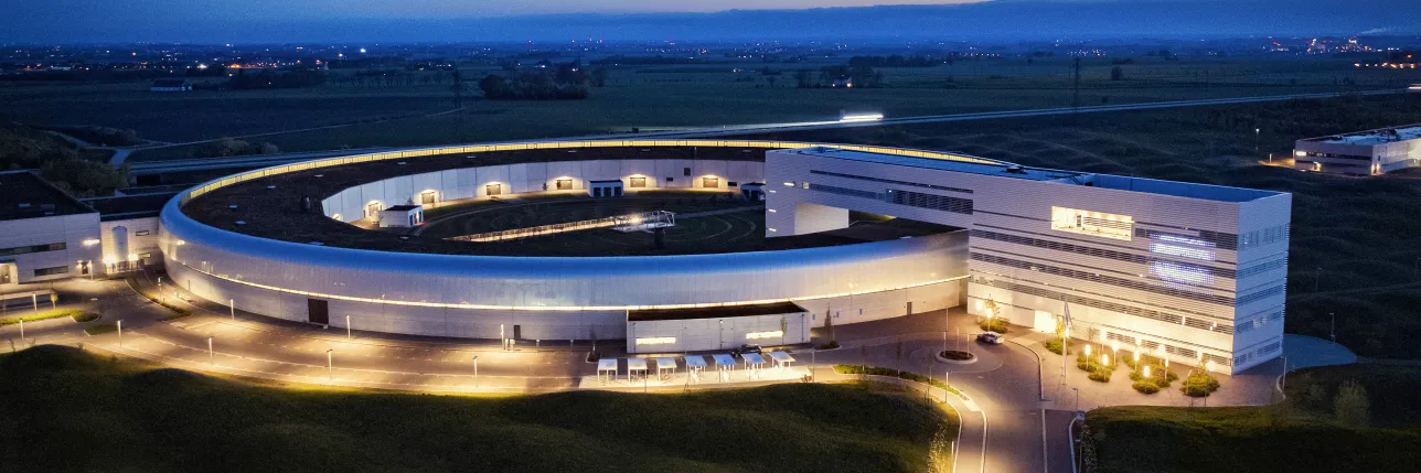 Illuminated circular building complex at night. Photo.