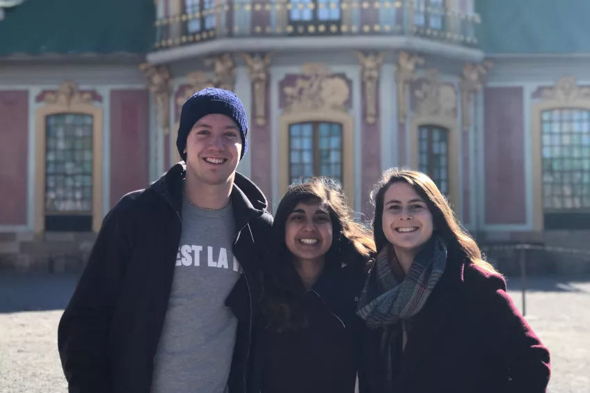 Three exchange students posing in front of a nice building