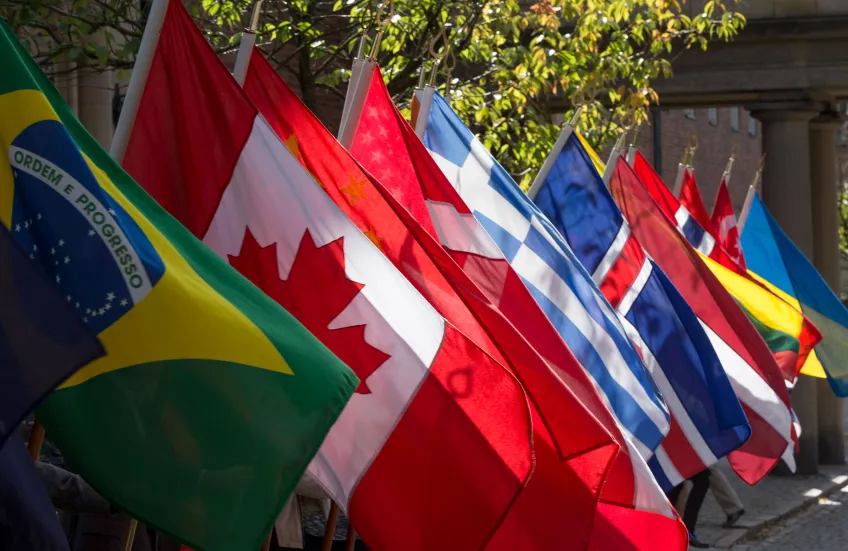 A bunch of large flags held by invisible hands outside