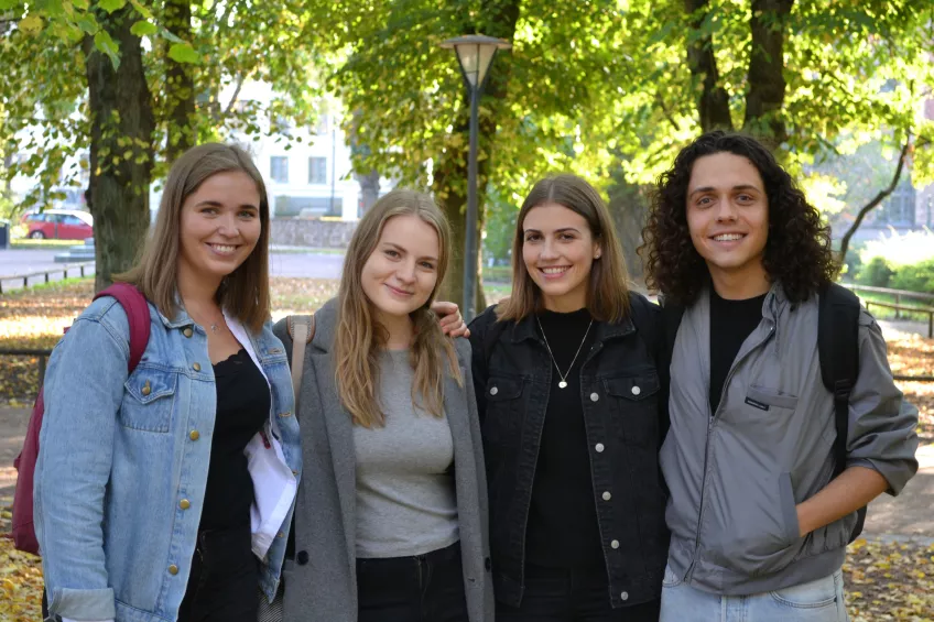 Four students looking posing and into the camera outside