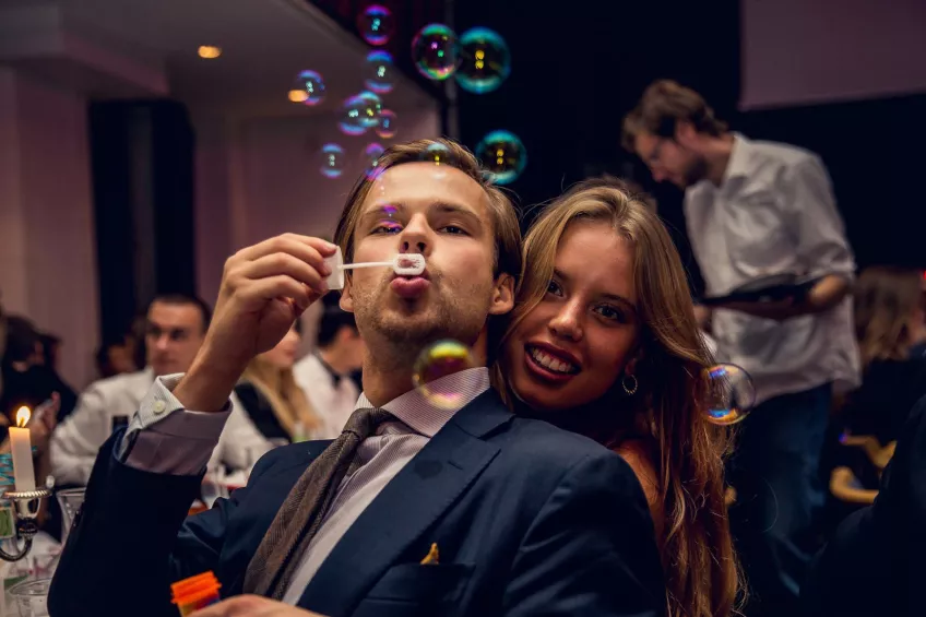 Students in fancy dress blowing bubbles at a sittning at a nation 