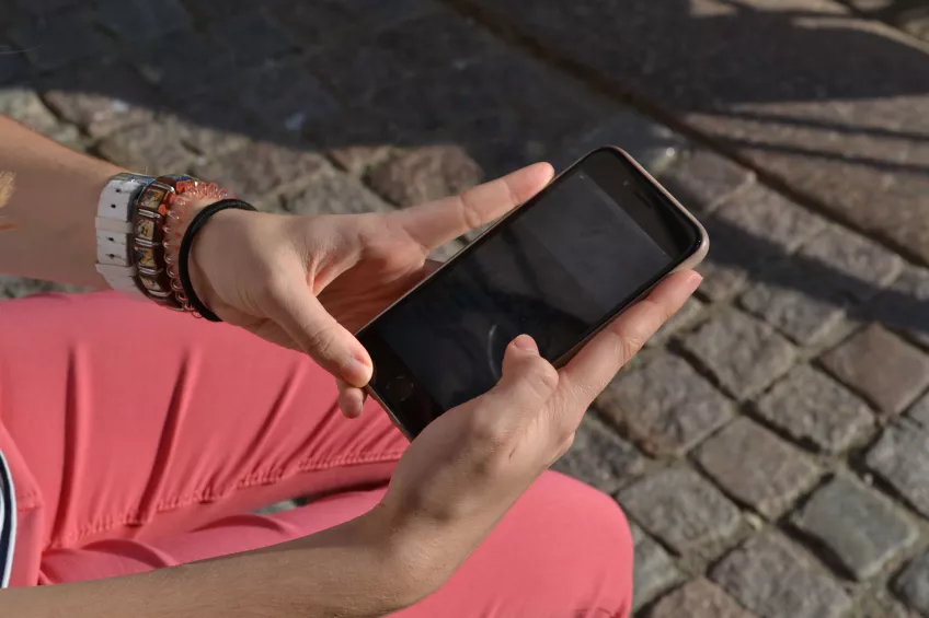 Hands holding a phone outside