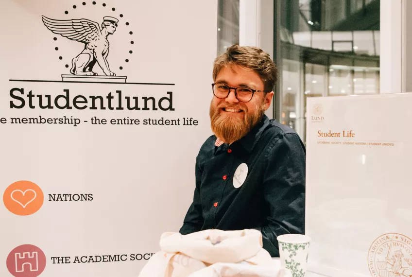 A Studentlund ambassador at an information booth at a fair