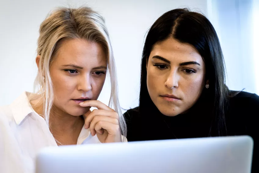 Two students looking at a laptop together