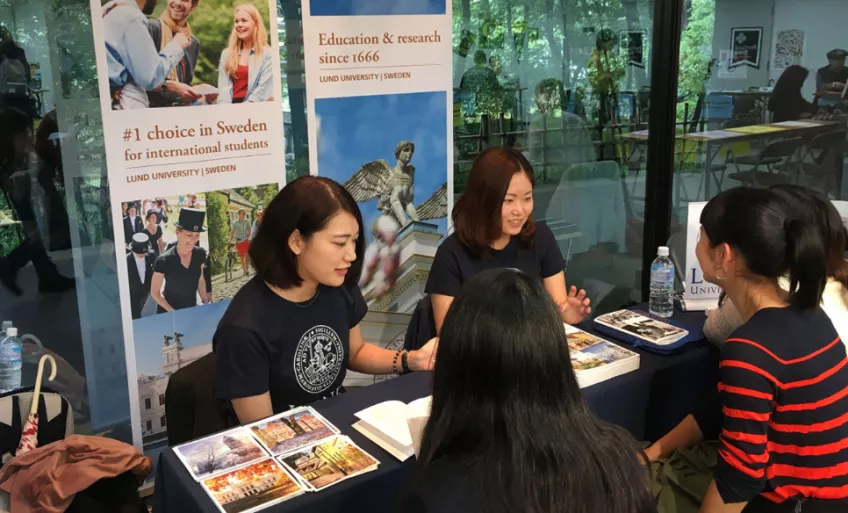 Student ambassadors talking to prospective students at a fair. Photo.