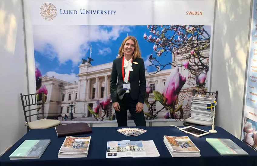 A Lund University Representative standing by our booth at a fair. Photo.